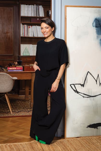 La diseñadora posa en la entrada de su estudio junto a otro cuadro de la artista Elisa Setien. Para este espacio, Gorof transformó una mesa de campo estilo francés del siglo XVI en su escritorio y la ubicó sobre una alfombra persa reciclada. De fondo, su vasta colección de revistas. “Mis papás me pedían que dejara de comprar revistas, son mi perdición”, confiesa entre risas.