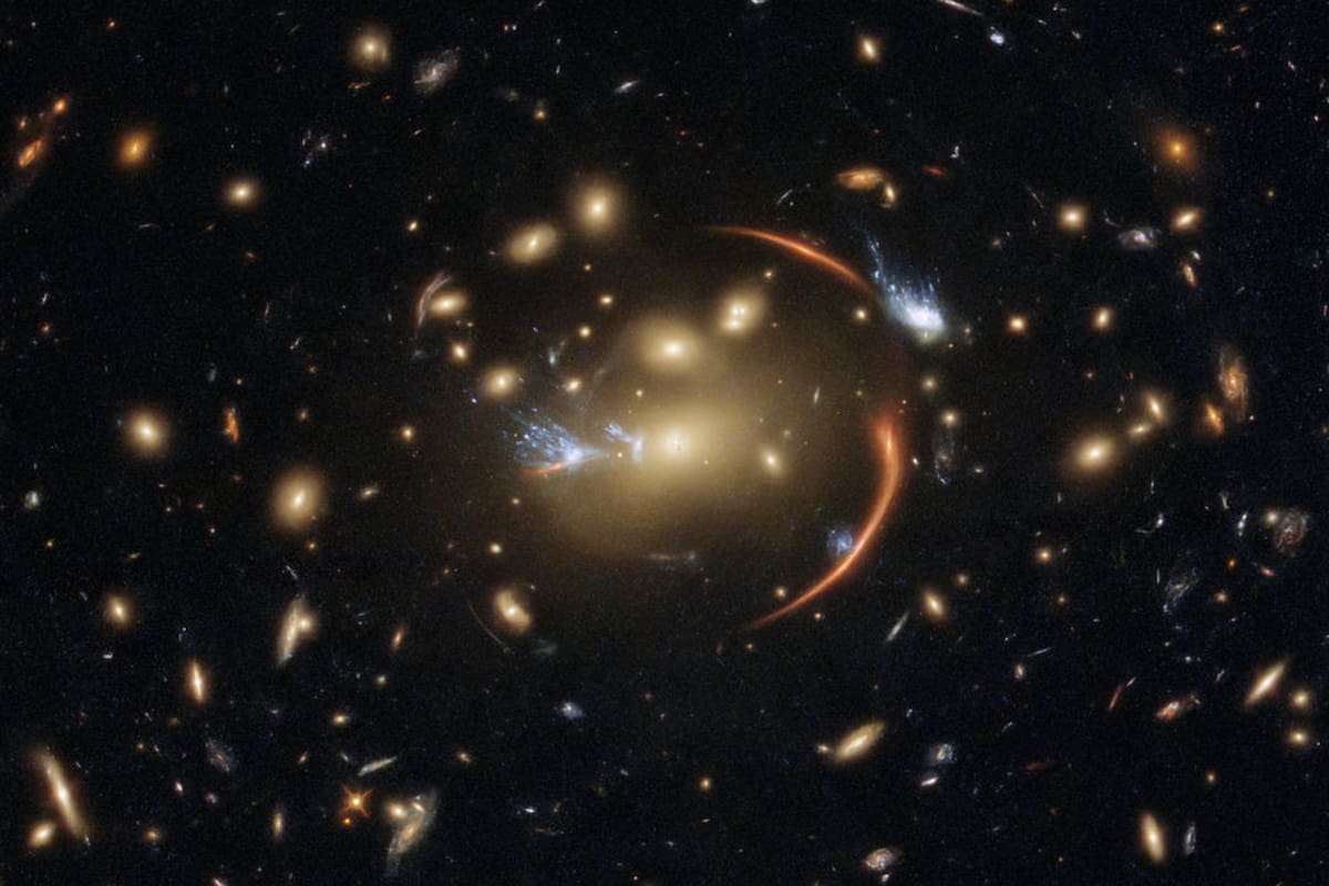 La distante galaxia MRG-M0138 w, captada por el Hubble con una lente gravitacional