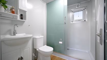 La distribución del espacio incluye una cocina con muebles de diseño moderno y un baño equipado, ofreciendo un ambiente cómodo y práctico para sus residentes