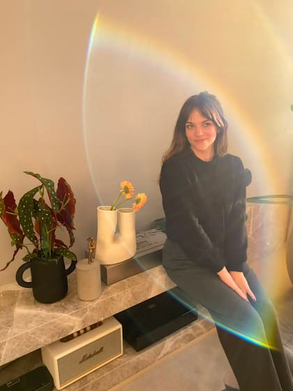 La dueña de casa, apoyada en el mueble de piedra del estar.