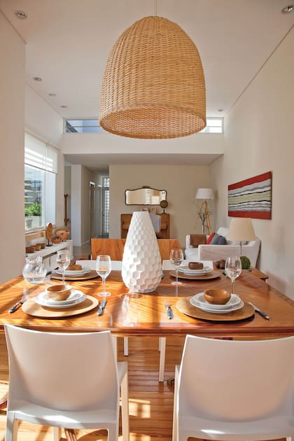 La dueña hizco la lámpara partir de una gran pantalla de mimbre. A la mesa heredada estilo Sheraton en pluma de caoba la rodearon con sillas plásticas de Mascardi, para sacarle cualquier formalidad. El pasillo lleva a los cuartos y termina en el patio.