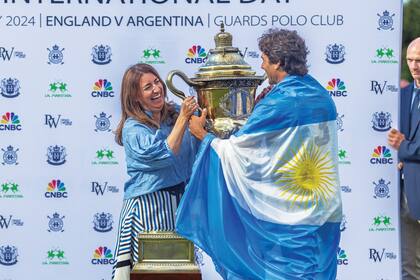 La embajadora argentina en el Reino Unido, Mariana Plaza, le entrega a Hilario la copa.