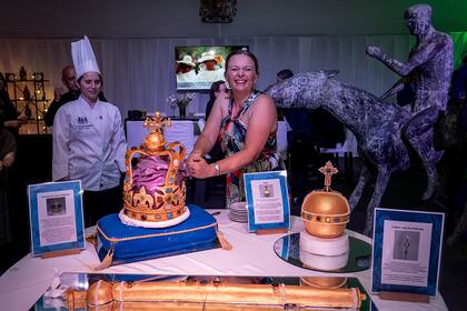 La embajadora corta la torta de cuatro pisos inspirada en la corona de San Eduardo, parte del festejo por el 75 cumpleaños del rey Carlos III. "Siguiendo la tradición, esta corona se utilizó en la Coronación de Su Majestad el Rey Carlos III celebrada en la Abadía de Westminster el 6 de mayo de 2023. Es la misma que llevó la Reina Isabel II cuando fue coronada en 1953", explicaron.