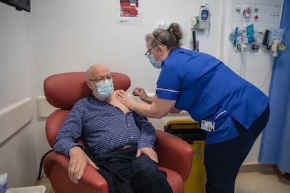 La enfermera Naomi Walsh administra la vacuna de Pfizer y BioNTech a Roger Shaw, de 87 años, en el hospital Royal Free de Londres el 8 de diciembre de 2020 al inicio del programa de vacunación más grande de la historia de Gran Bretaña