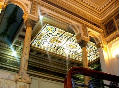 La escalera conecta los niveles de la residencia y culmina bajo un gran vitral que ilumina el interior desde lo alto