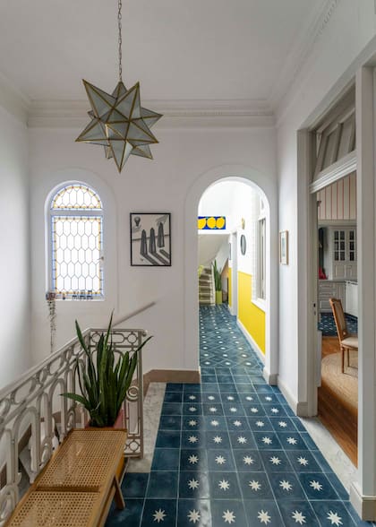 La escalera desemboca en un pasillo que conecta todos los ambientes y termina en la escalera que conduce a la terraza, el segundo escritorio y la suite. Estrella en vidrio y bronce, obra de un artista marplatense