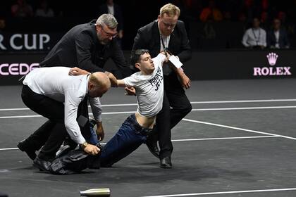 La escena final, con el protestante sacado del court, durante el descanso de Schwartzman-Tsitsipas