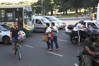 Malos hábitos. Cruzar entre los vehículos detenidos en un semáforo es muy peligroso