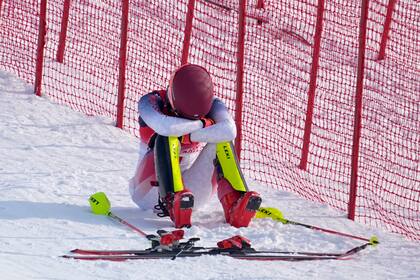 La estadounidense Mikaela Shiffrin se sienta a un lado de la pista tras salirse del recorrido en la primera ronda de slalon femenino en los Juegos Olímpicos de Invierno de 2022 en Beijing, el miércoles 9 de febrero de 2022 en el distrito de Yanqing, Beijing. (AP Foto/Robert F. Bukaty)