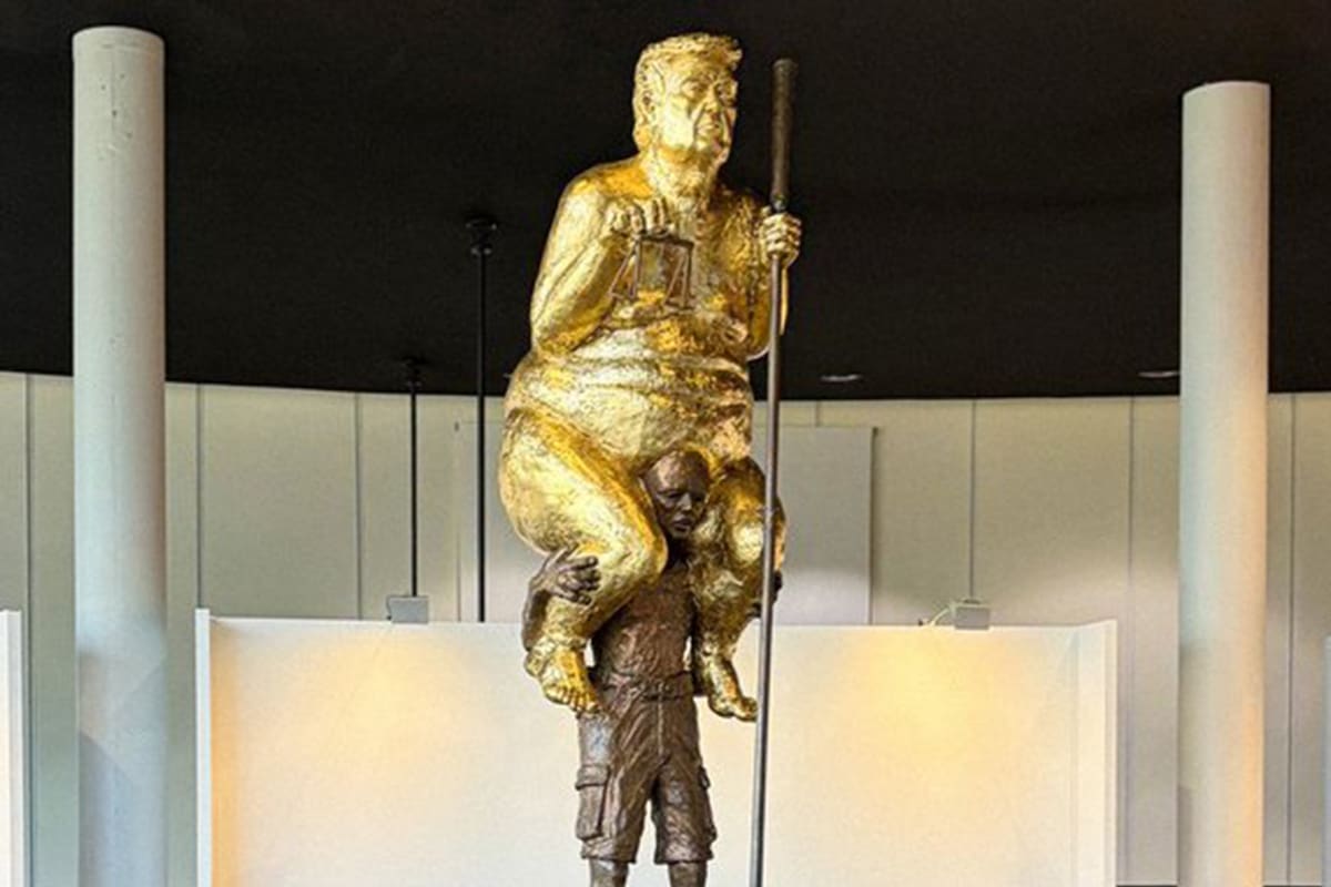 La estatua dorada de Trump desnudo subido a los hombros de un hombre que se exhibe en Francia