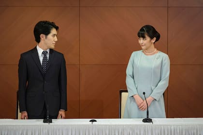 La ex princesa Mako de Japón, a la derecha, la hija mayor del príncipe Akishino y la princesa Kiko, y su esposo Kei Komuro, se miran durante una conferencia de prensa para anunciar su boda en un hotel en Tokio, Japón, el martes 26 de octubre de 2021