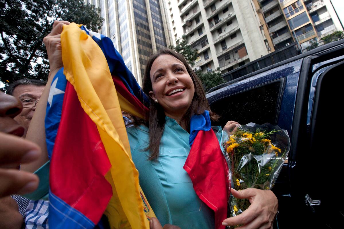 La exdiputada y líder opositora María Corina Machado sostiene la bandera venezolana frente a la Fiscalía General de la República, el 3 de diciembre de 2014, en Caracas, Venezuela