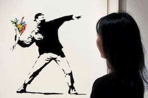 La exposición incluirá una de las imágenes más conocidas del grafitero británico, "El amor está en el aire", que muestra a un manifestante dispuesto a lanzar flores en lugar de piedras o bombas. Por una versión de esa pieza se pagó el año pasado en Sotheby’s de Nueva York el equivalente en criptomonedas a 12,9 millones de dólares