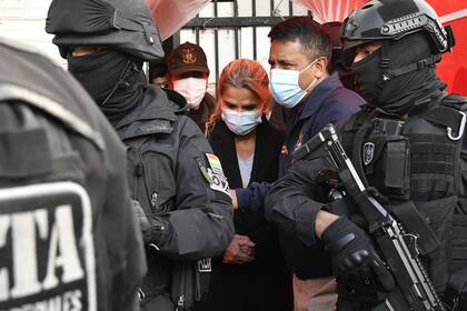 La expresidenta interina de Bolivia, Jeanine Ánez, es escoltada por policías de la Fuerza Especial contra el Crimen luego de ser detenida en La Paz, el 13 de marzo de 2021