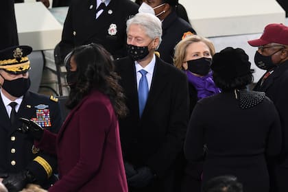 La exprimera dama Michelle Obama y la excandidata Hillary Clinton, vestidas de púrpura en la asunción de Biden