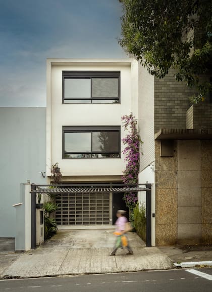 La fachada es el punto de partida. En planta baja, una composición de ladrillos cobogó define la identidad visual del proyecto incluso antes de entrar.
