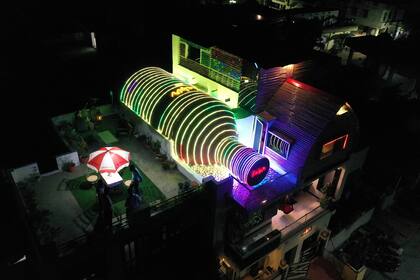 La fachada se ilumina por la noche con las tiras de luces que decoran la gran botella