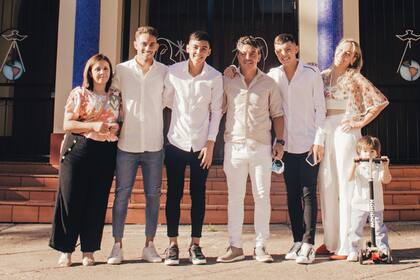 La familia Gallardo en pleno y Marcela Acosta, la madrina, posan frente a la parroquia Natividad del Señor, en Rosario. El homenajeado posa en su monopatín.