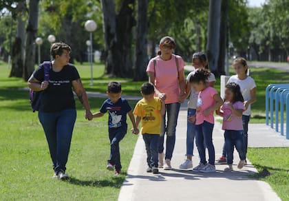 La familia pasea por una plaza de la pequeña localidad de Luis Palacios, que se revolucionó con la llegada de los chicos dos semanas atrás. Ya están anotados en la escuela, que queda a seis cuadras de su casa.