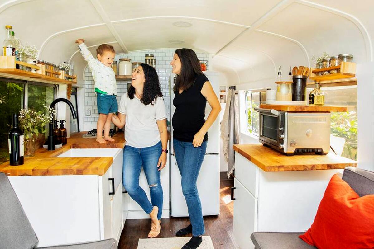 La familia posa en la cocina de la casa rodante en la que viven