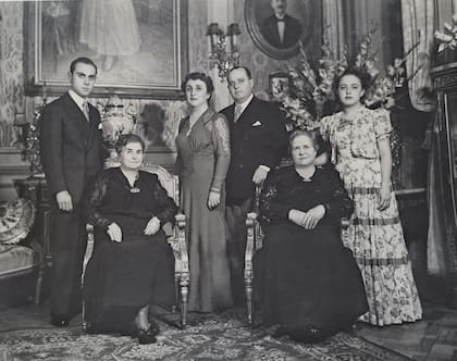 La familia Spota-Azaretto fotografiada en 1943 en el living de la casa atribuida al arquitecto Mario Palanti, sobre la calle Viamonte 1871. De izquierda a derecha, de pie: Alberto Spota, Ángela Catalina Azaretto, Víctor Spota, Beatriz Ángela Spota. Sentadas: Luisa Campodónico de Azaretto (esposa de Luis) y Ángela Colomba Spota (madre de Víctor Spota). Detrás, sobre la pared, el retrato ovalado de Luis Azaretto.
