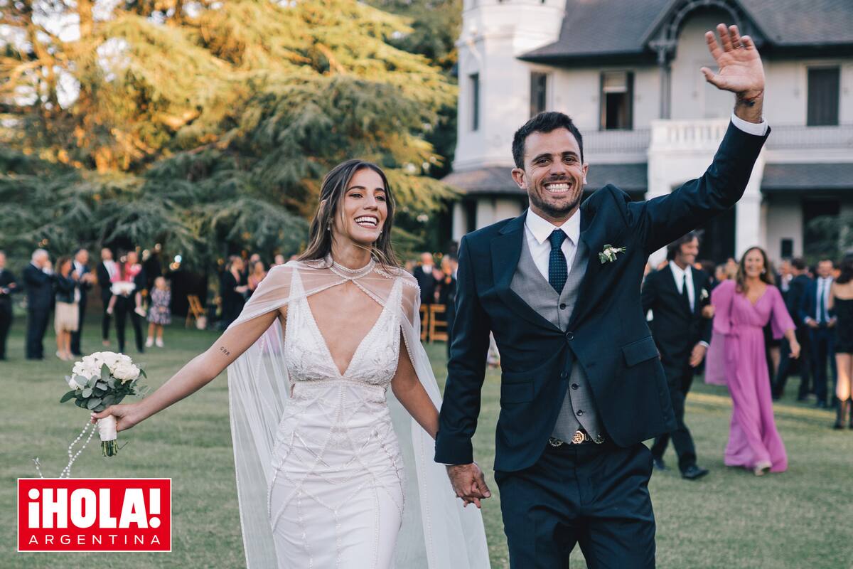 La feliz pareja camina tomada de la mano por el inmenso parque, con el castillo Pando Carabassa detrás. Ella llevó un sensual vestido de corte sirena con escote profundo y capa y él, optó por traje con chaleco y rastra criolla.