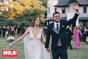 La feliz pareja camina tomada de la mano por el inmenso parque, con el castillo Pando Carabassa detrás. Ella llevó un sensual vestido de corte sirena con escote profundo y capa y él, optó por traje con chaleco y rastra criolla.