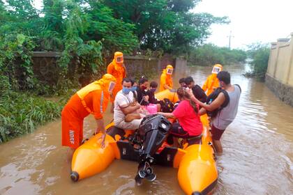 La foto distribuida por la Fuerza Nacional de Respuesta a los Desastres (NDRF) de la India muestra personal de la agencia cuando rescata a gente de la inundación en Bhiwandi, esrado de Maharashtra, 22 de julio de 2021. ( Fuerza Nacional de Respuesta a los Desastres via AP)