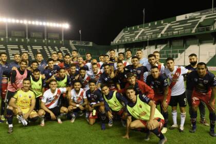 La foto grupal entre los futbolistas de los dos equipos luego del partido