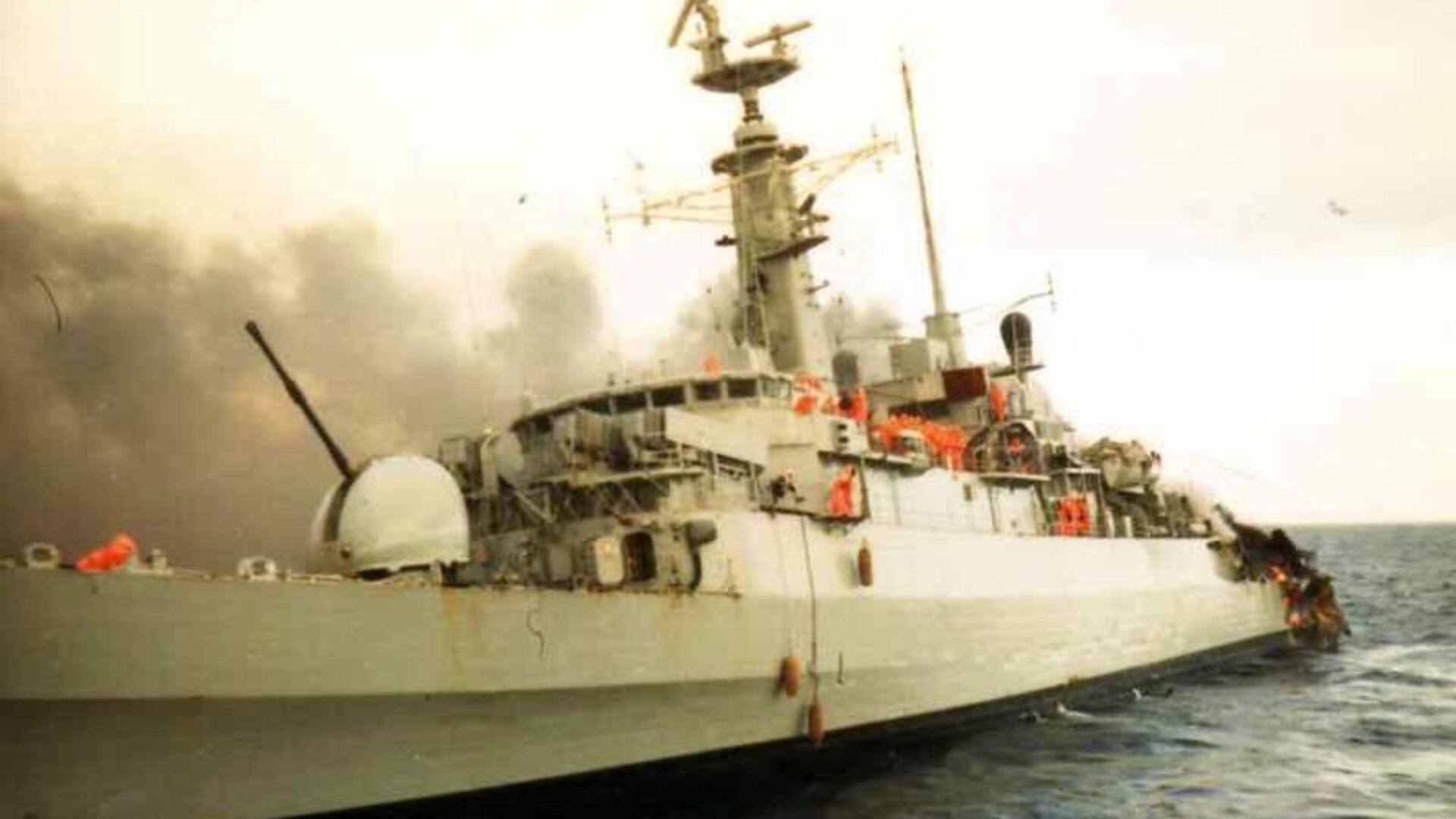 La fragata HMS Ardent en llamas, en sus últimas horas. Su tripulación, con trajes antiflama naranjas, se prepara para el abandono
