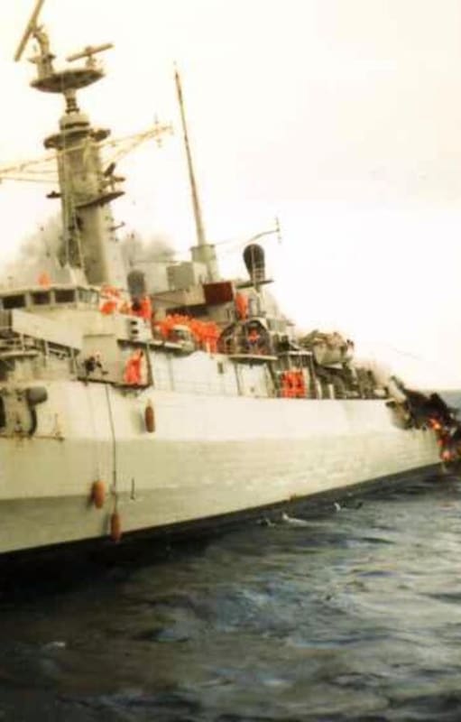 La fragata HMS Ardent en llamas, en sus últimas horas. Su tripulación, con trajes antiflama naranjas, se prepara para el abandono