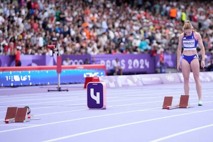 La francesa Helene Parisot de pie frente al puesto de salida de la jamaicana Shericka Jackson en las eliminatorias de los 200 metros femeninos del atletismo de los Juegos Olímpicos, el domingo 4 de agosto de 2024, Saint-Denis, Francia. (AP Foto/Bernat Armangue)