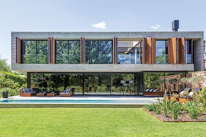 La galería junto a las enormes ventanas corredizas tiene cerrado el extremo derecho. Allí dentro, como parte de la casa, está la parrilla.
