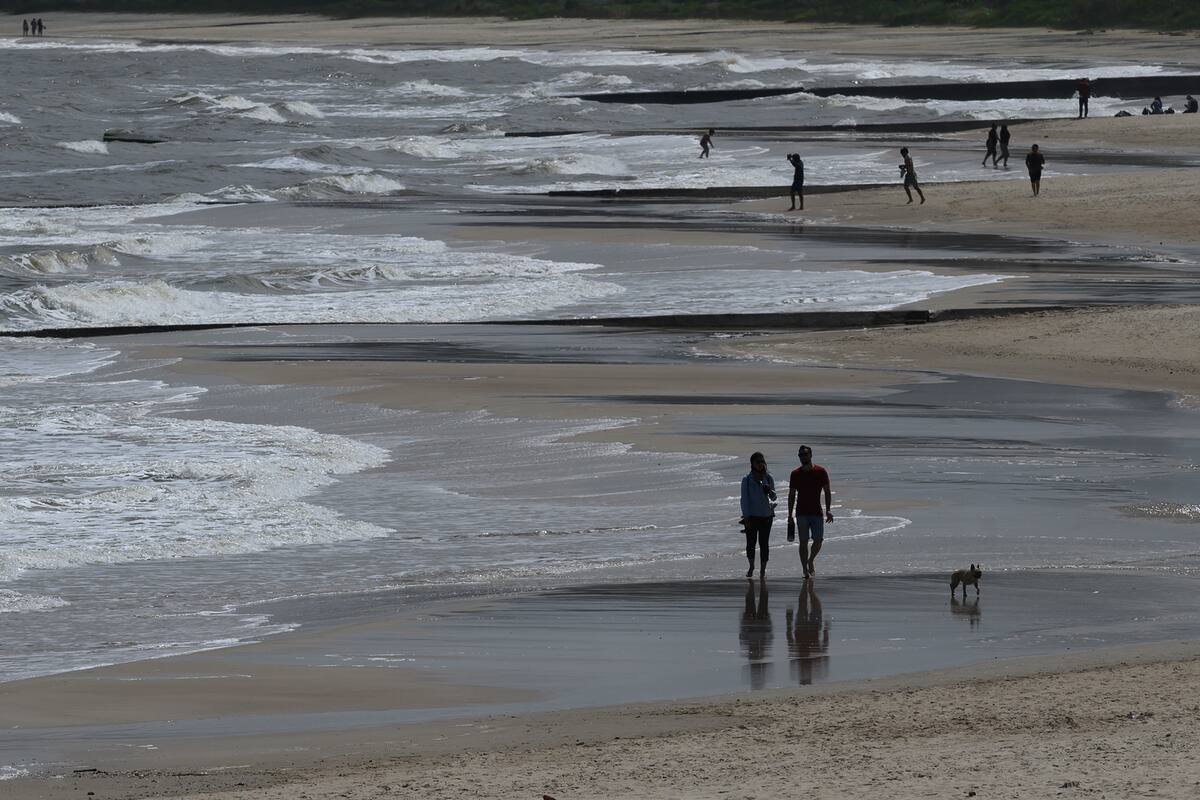 La gente camina por la playa en Atlántida, departamento de Canelones, Uruguay, el 15 de noviembre de 2020, en medio de la pandemia de coronavirus