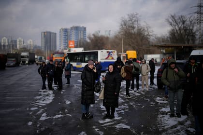 La gente espera en una calle bloqueada por la policía después de un ataque con cohetes en Kiev, Ucrania