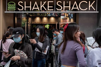 La gente hace cola frente a un restaurante Shake Shack afuera de un centro comercial durante el feriado nacional de la "Semana Dorada" en Pekín el 2 de octubre de 2020.