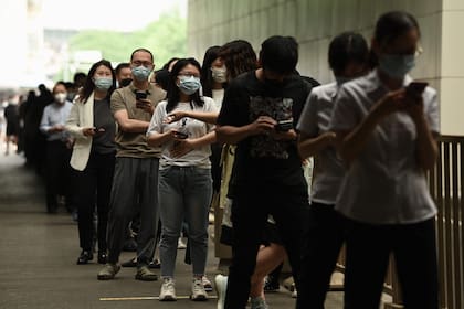 La gente hace cola para hacerse la prueba del Covid-19 en un sitio de recolección de hisopos en Pekín el 9 de junio de 2022. (Photo by Noel Celis / AFP)