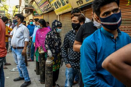 La gente hace fila con tubos de oxígeno para cambiarlos para recargarlos en una tienda al sur de Delhi. Casi la mitad de la demanda de oxígeno médico mundial se concentra en la India