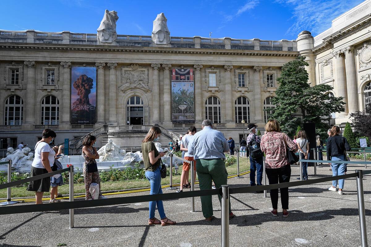 La gente hace fila fuera del Grand Palais el 1 de julio de 2020 durante el primer día de la reapertura en París