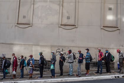 La gente hace fila para obtener comida frente a una organización benéfica católica en São Paulo. Decenas de millones de brasileños enfrentan hambre o inseguridad alimentaria a medida que se prolonga la crisis del COVID-19