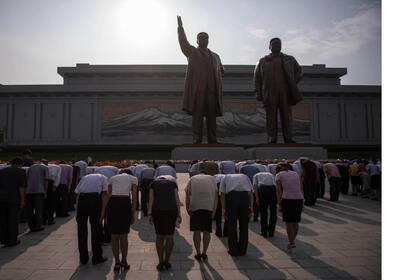 La gente hace una reverencia al rendir homenaje a las estatuas de los ex líderes norcoreanos Kim Il-Sung y Kim Jong-Il, en la colina de Mansu en Pyongyang