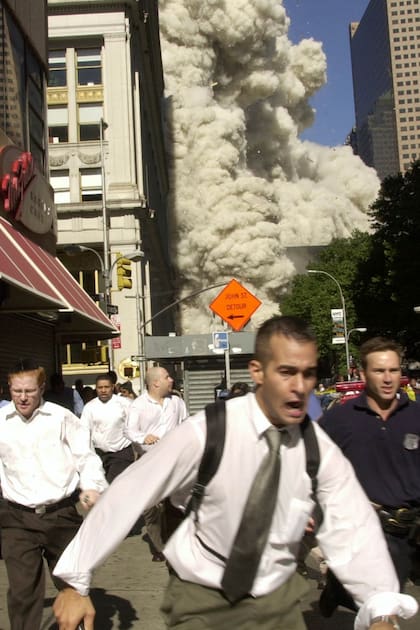 People run from the collapse of World Trade Center Tower  Tuesday, Sept. 11, 2001 in New York. (AP Photo/Suzanne Plunkett)