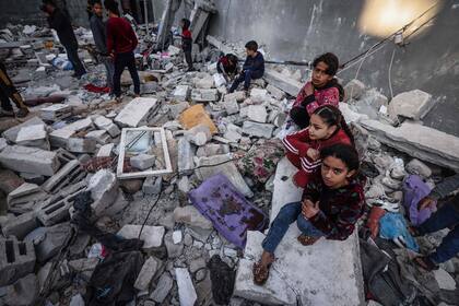 La gente inspecciona los daños tras el bombardeo israelí en Rafah, en el sur de la Franja de Gaza, el 29 de diciembre de 2023, en medio de las batallas en curso entre Israel y el grupo militante palestino Hamas