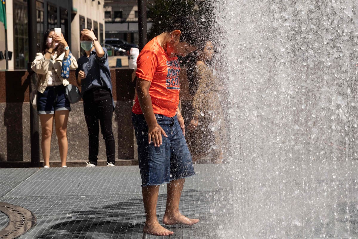 La gente juega en la escultura a base de agua del artista Jeppe Hein titulada "Changing Spaces" en el Rockefeller Center Plaza en la ciudad de Nueva York