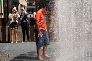 La gente juega en la escultura a base de agua del artista Jeppe Hein titulada "Changing Spaces" en el Rockefeller Center Plaza en la ciudad de Nueva York