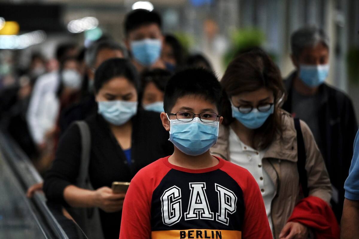 La gente llega con barbijos al aeropuerto de Wuhan