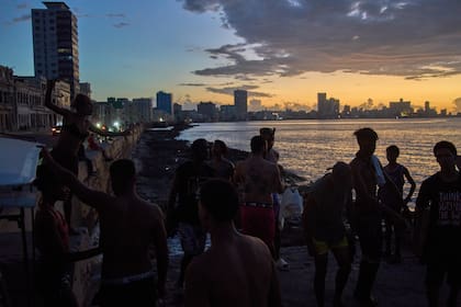 La gente observa la puesta de sol desde el Malecón durante un apagón en La Habana