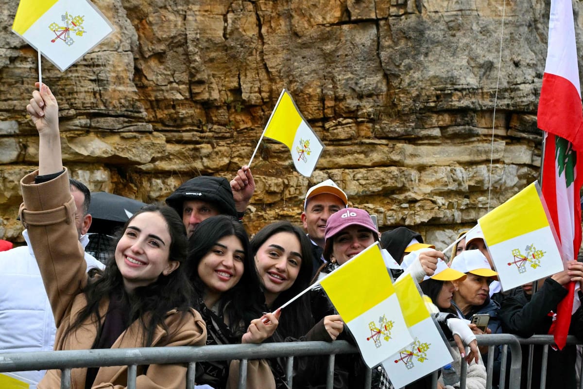 La gente ondea banderas del Vaticano mientras espera la llegada del Papa León XIV antes de su visita a la tumba de San Charbel Makhlouf en el monasterio de San Marón, en el pueblo montañoso de Annaya, el 1 de diciembre de 2025