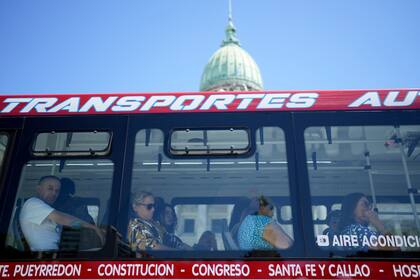 La gente pasa por el Congreso en Buenos Aires, Argentina, el jueves 7 de marzo de 2024. Algunas líneas de autobuses que circulan por la capital y sus alrededores realizaron una huelga el 7 de marzo para exigir el pago de aumentos salariales atrasados. (AP Foto/Natacha Pisarenko)