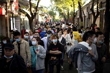 La gente pasea durante la festividad nacional de la "Semana Dorada" hoy en Pekín